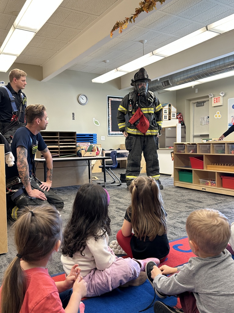firefighter showing students his uniform