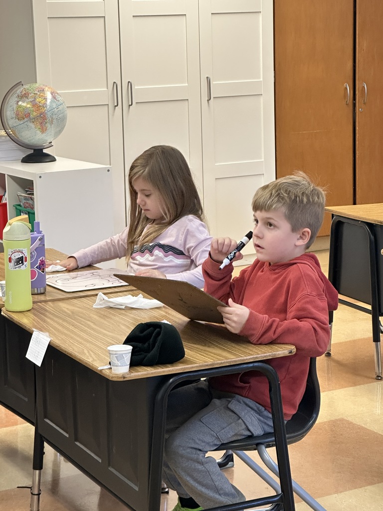 first grade students working on math problems at their desk