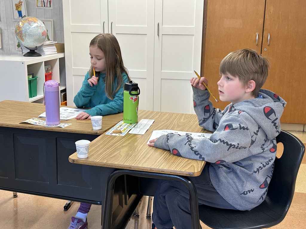 first grade students working on math problems at their desk
