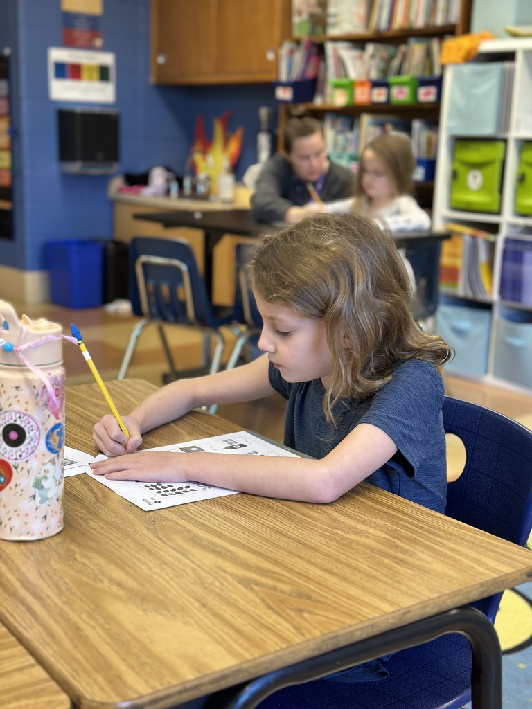 first grade student sitting at her desk working on math