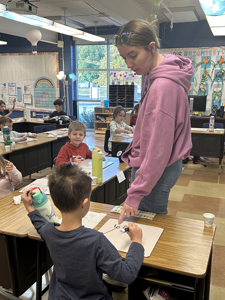 first grade teacher helping a student at his desk