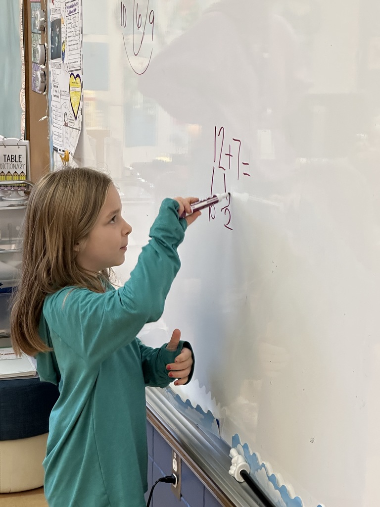 first grade student student writing on the white board