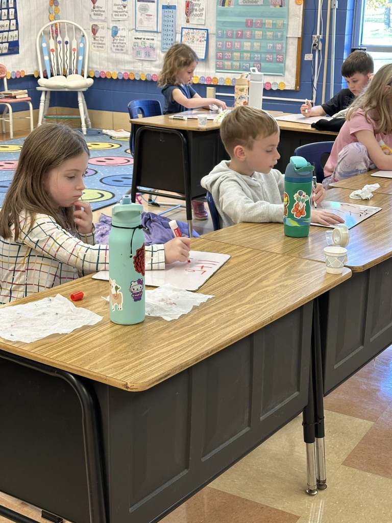 first grade students working on math problems at their desk