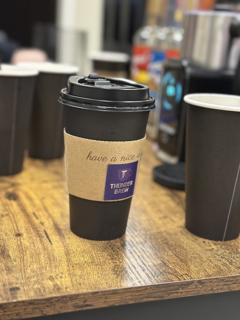 cup of coffee with a "Thunder Brew" sticker on the sleve