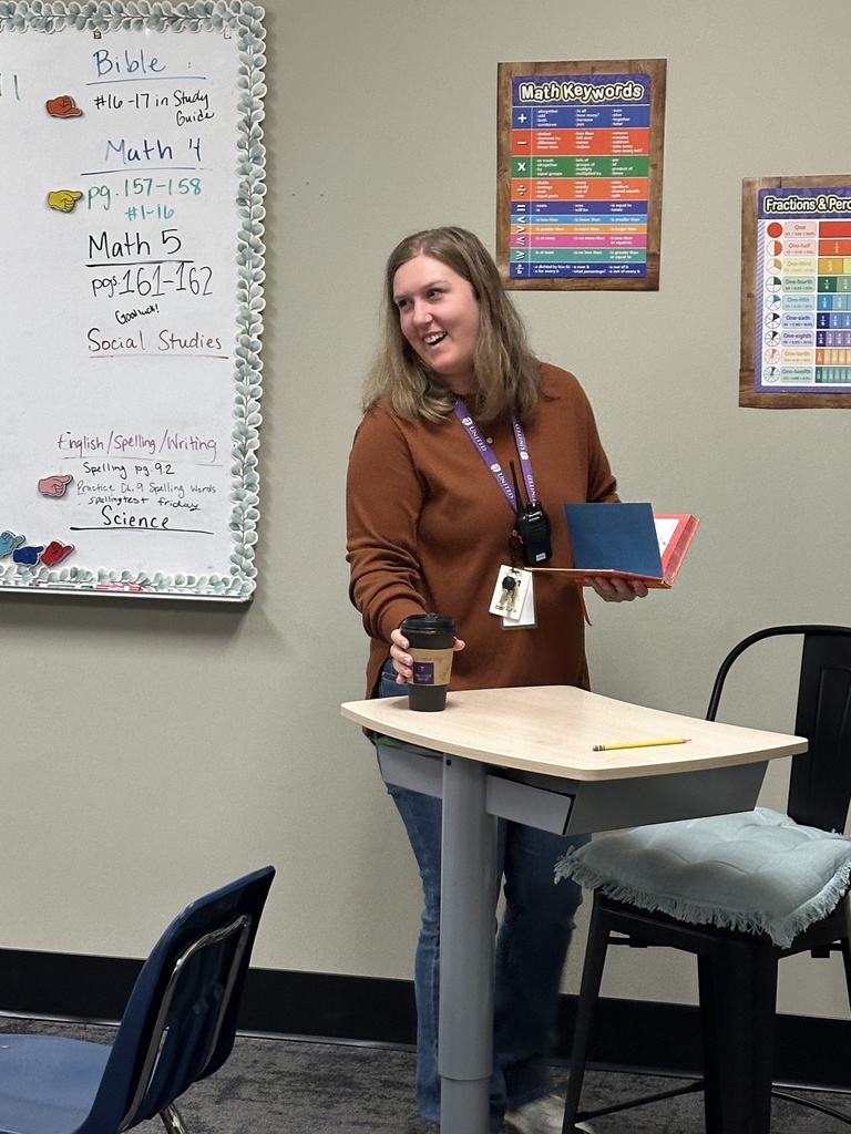 teacher smiling with a cup of coffee in her hand
