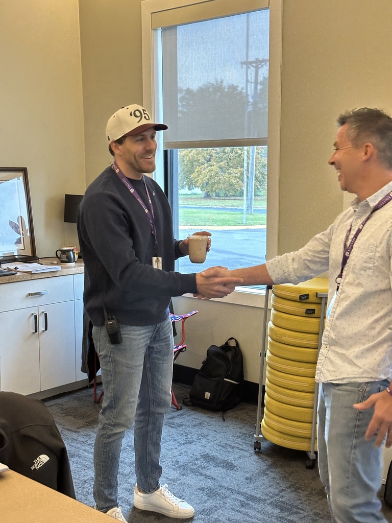 head of school shaking hands with a teacher after delivering him a coffee
