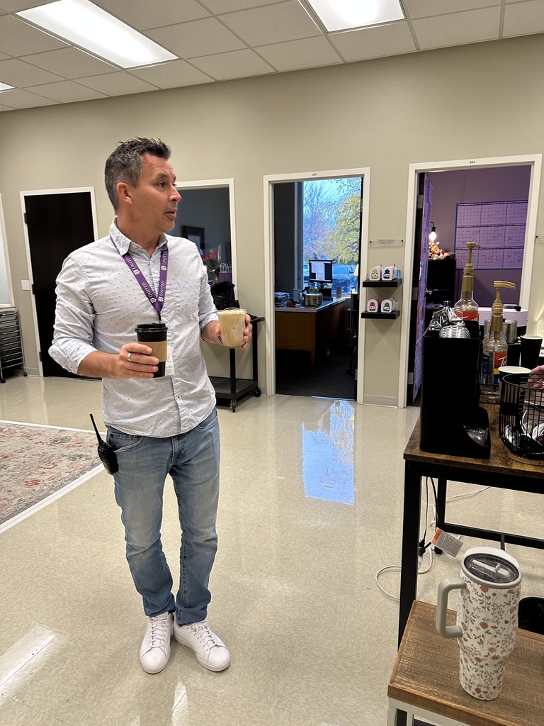head of school holding two coffee drinks to be delivered