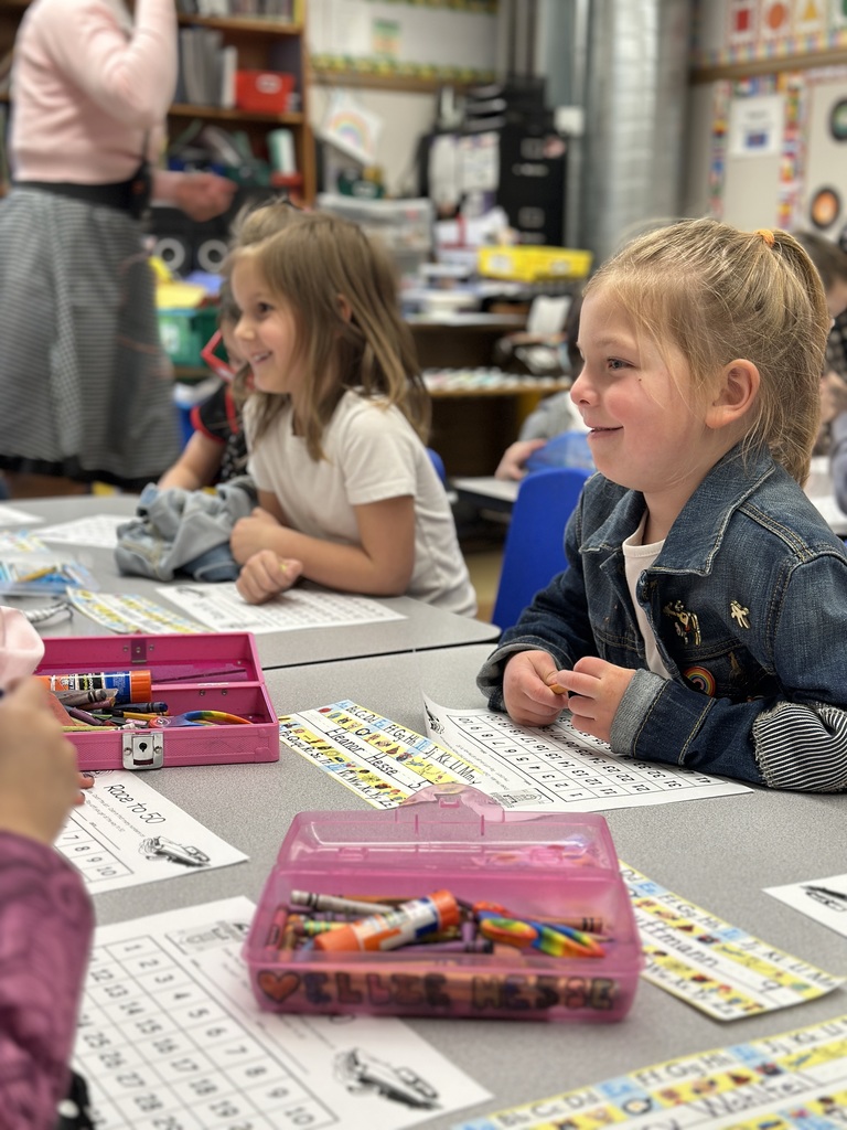 students working at their desk smiling at classmates