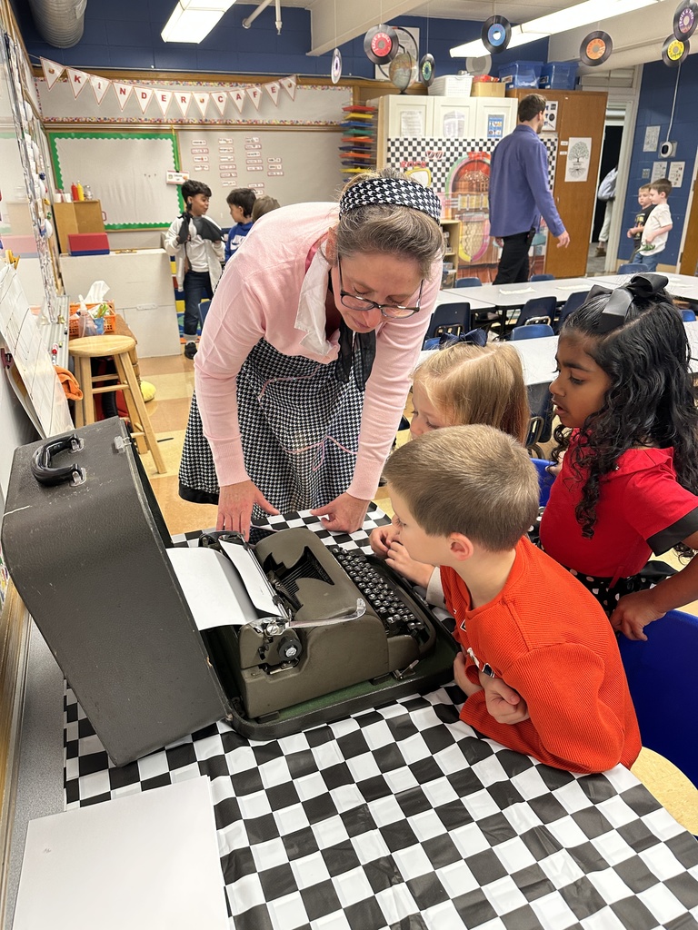 teacher showing her students what a typewriter is