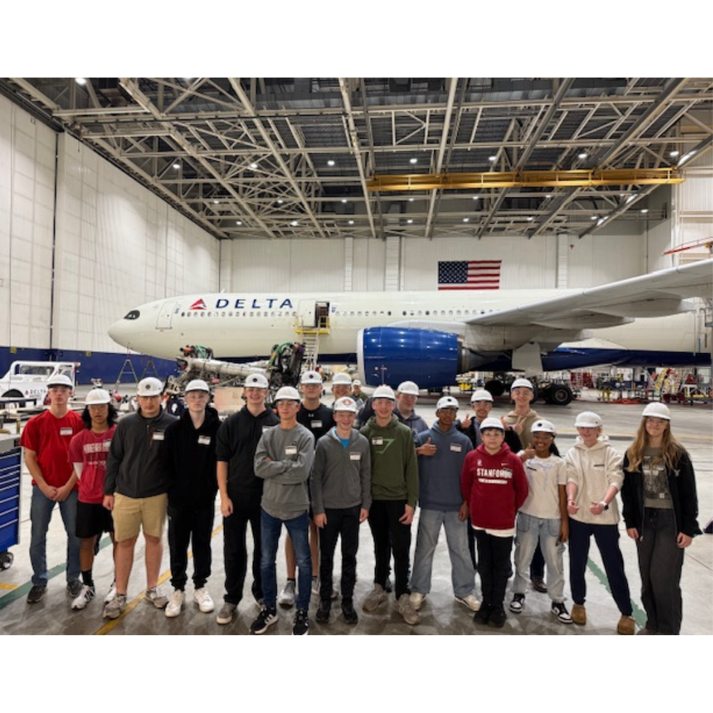 aviation students standing in front of a Delta plane