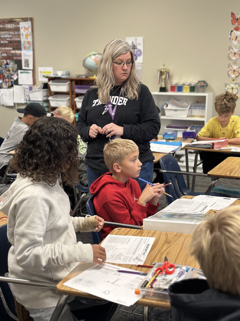 4th grade students working in pairs at their desks doing a science experiment