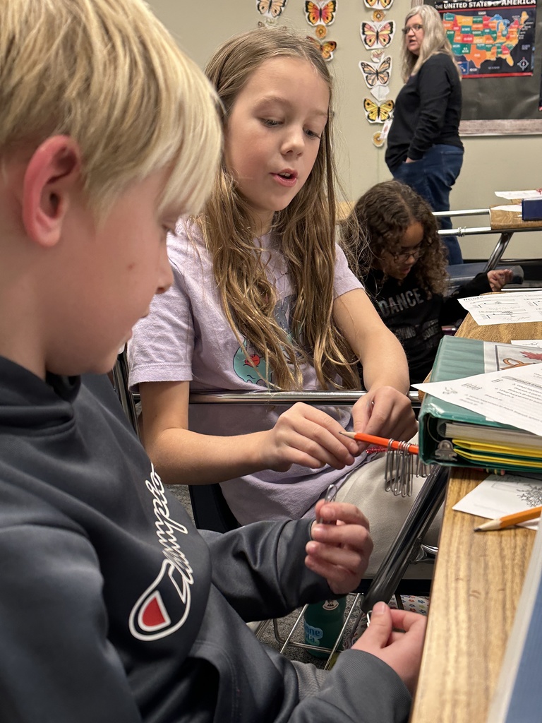 4th grade students working in pairs at their desks doing a science experiment
