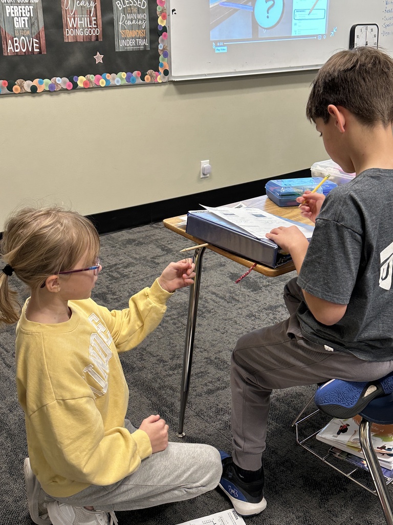 4th grade students working in pairs at their desks doing a science experiment