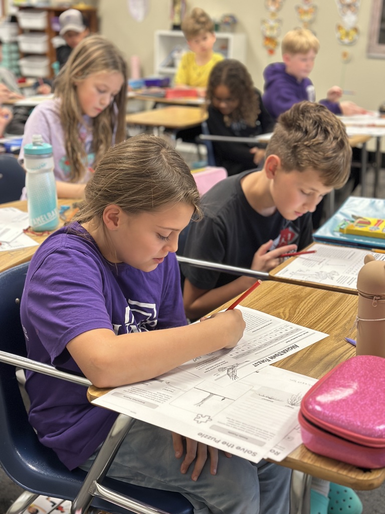 4th grade students working in pairs at their desks doing a science experiment