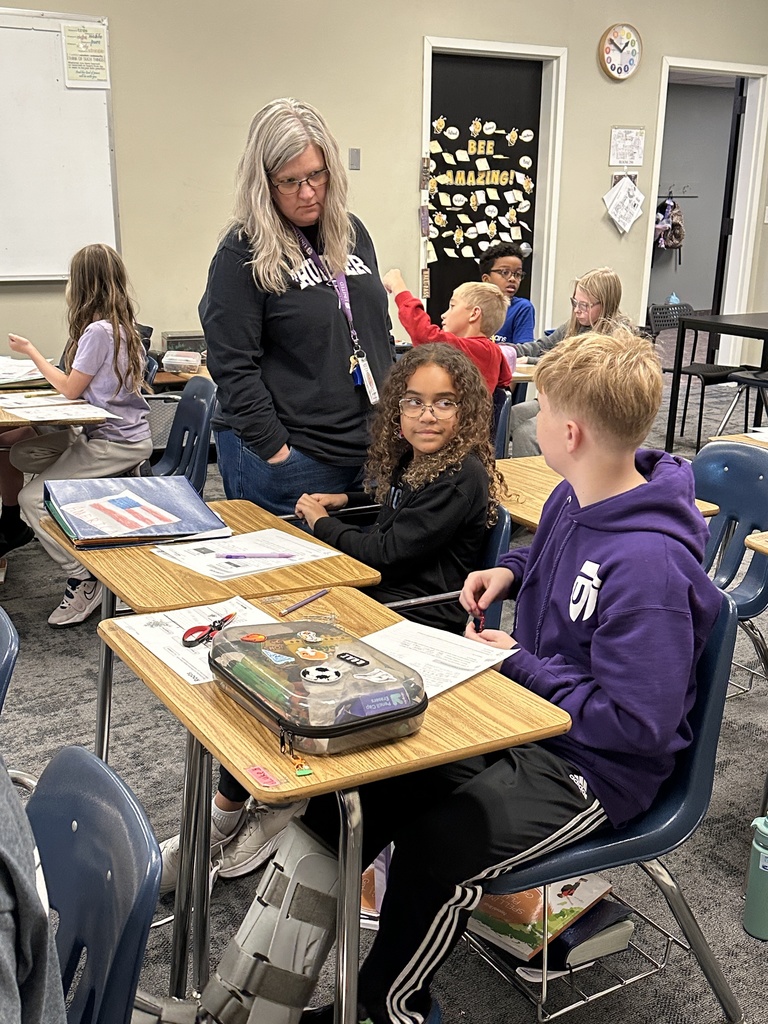 4th grade students working in pairs at their desks doing a science experiment