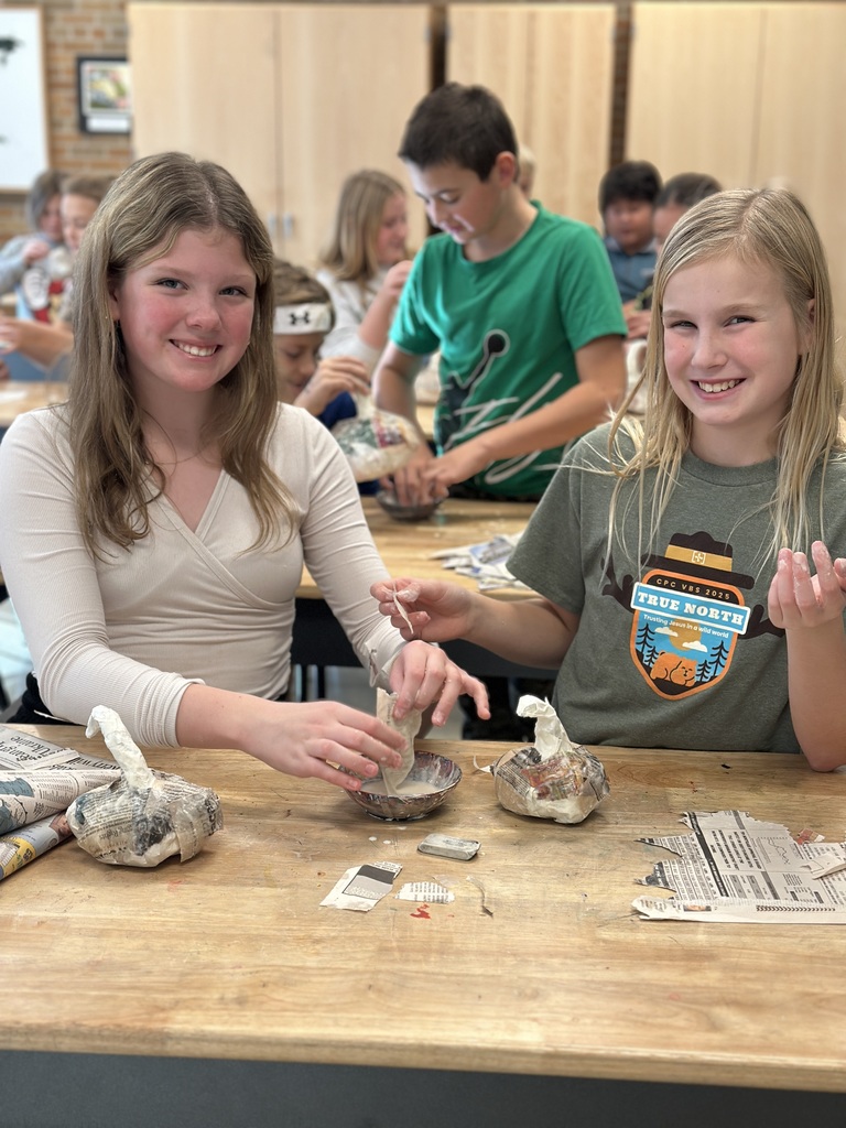6th grade students making paper mache pumpkins in art class