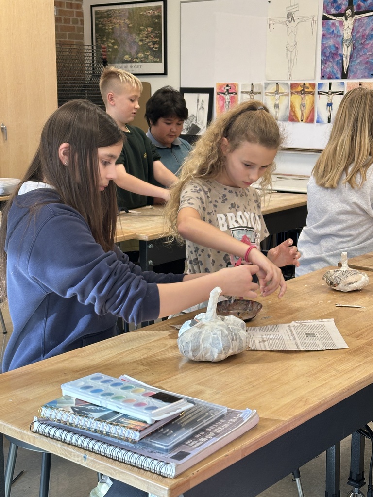 6th grade students making paper mache pumpkins in art class