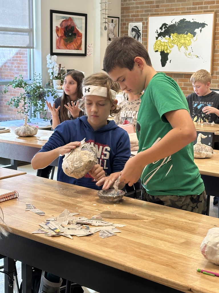 6th grade students making paper mache pumpkins in art class