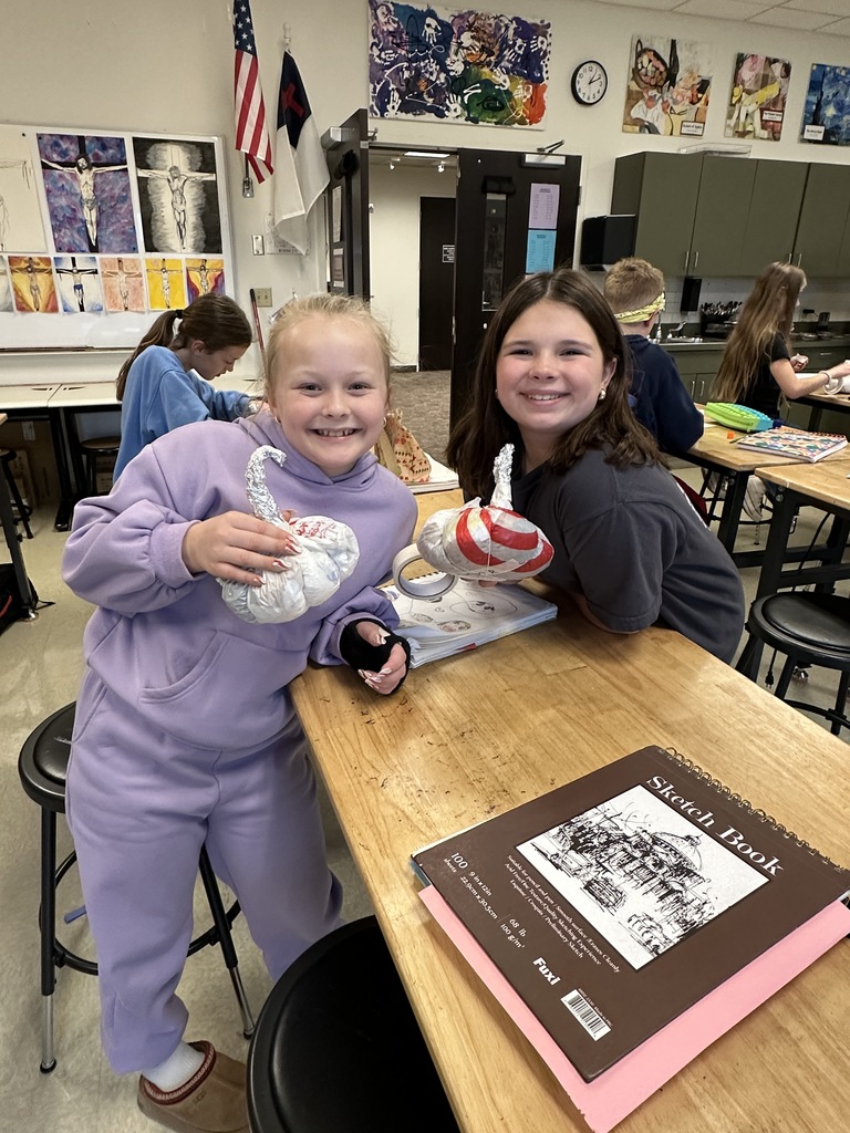 6th grade students making paper mache pumpkins in art class