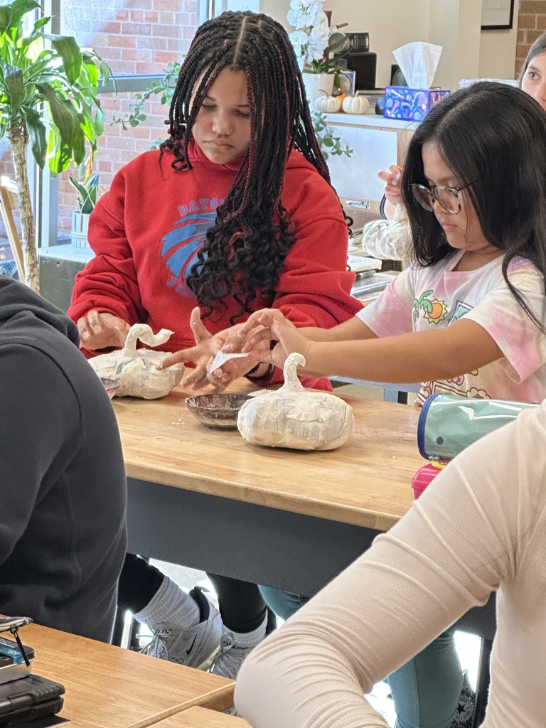 6th grade students making paper mache pumpkins in art class