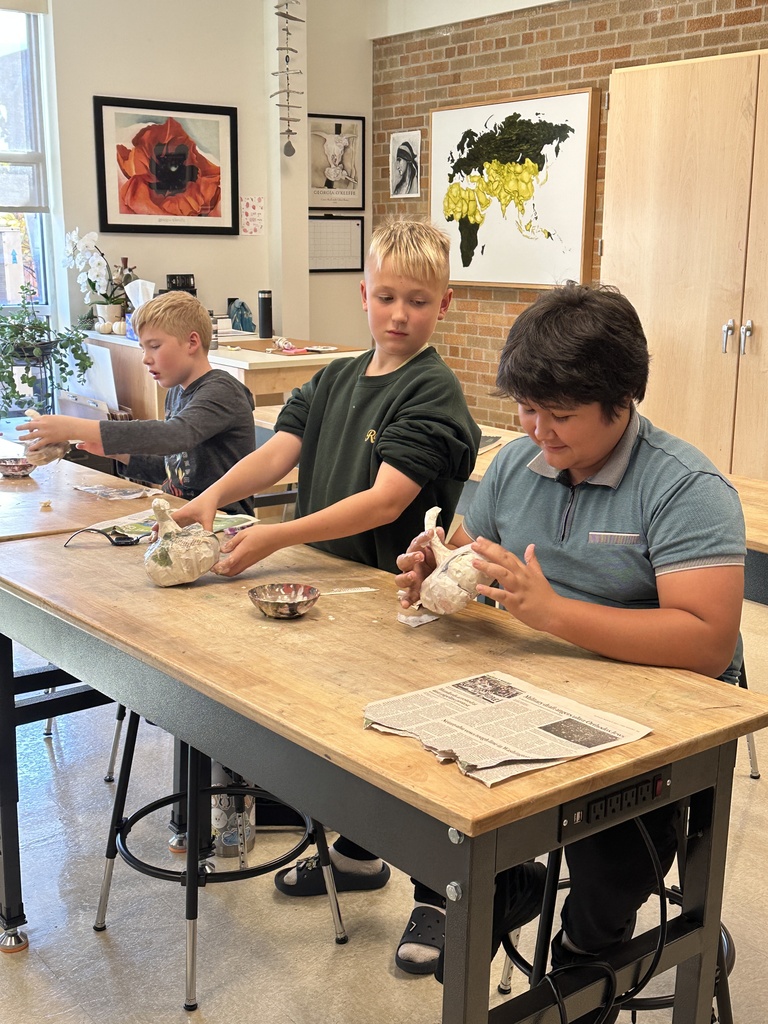 6th grade students making paper mache pumpkins in art class