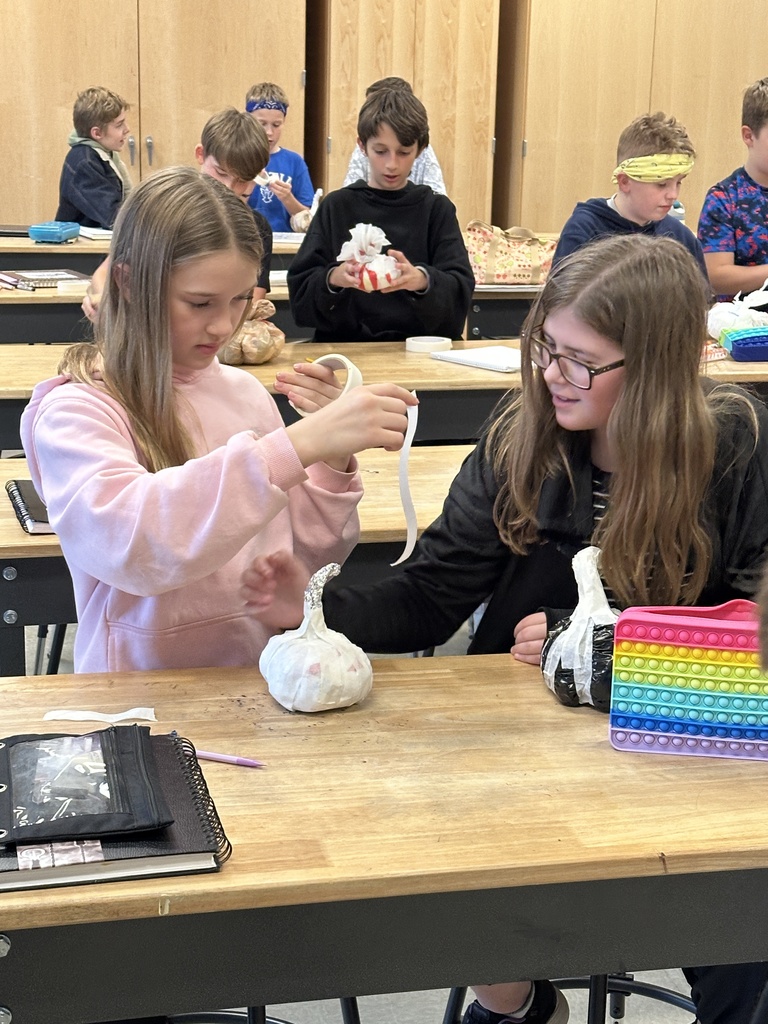 6th grade students making paper mache pumpkins in art class