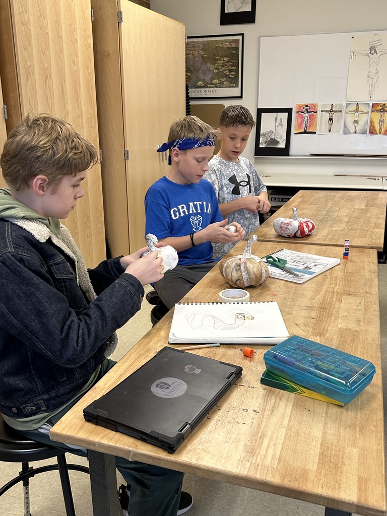 6th grade students making paper mache pumpkins in art class