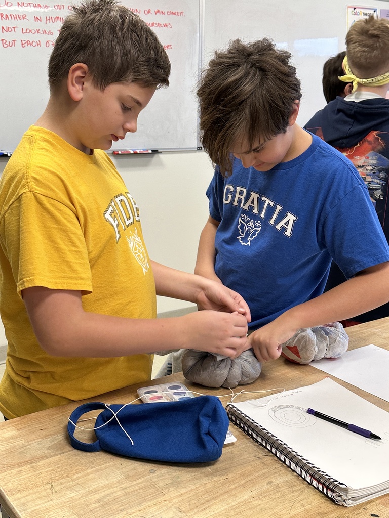 6th grade students making paper mache pumpkins in art class