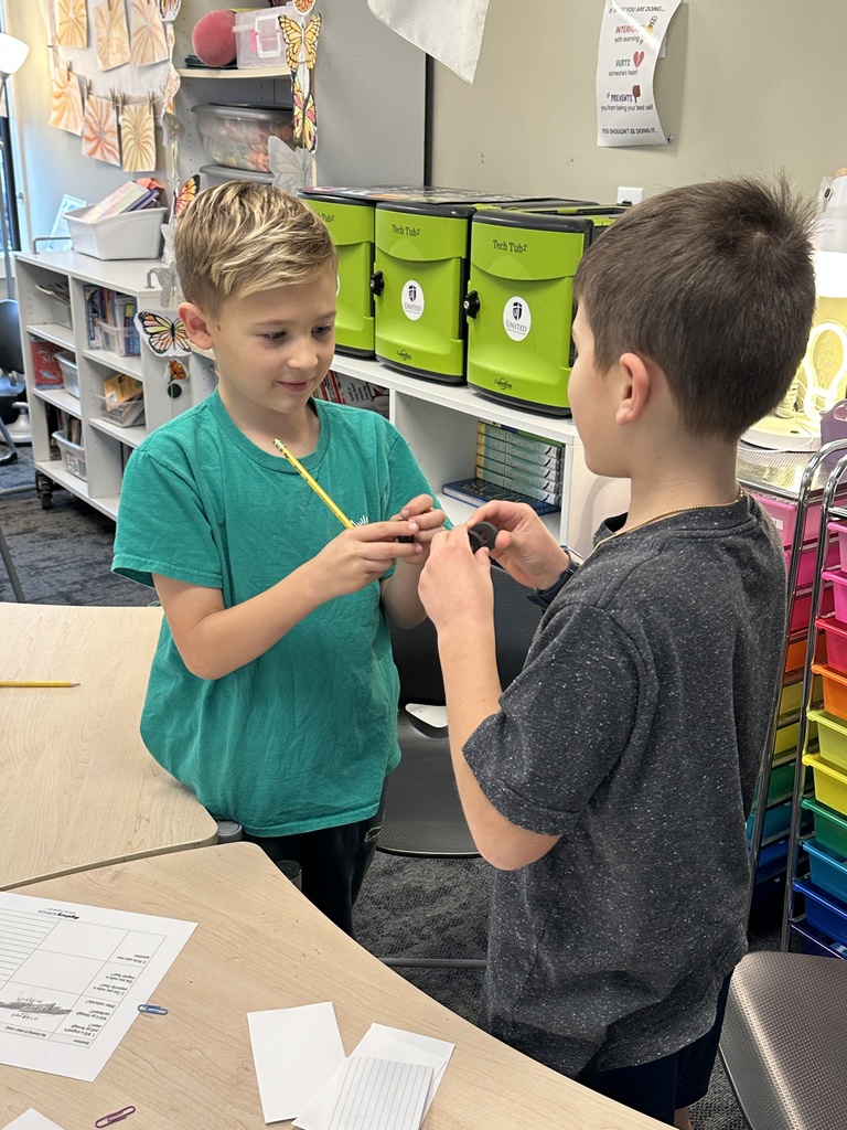 two students facing each other showing each other the magnets in their hands