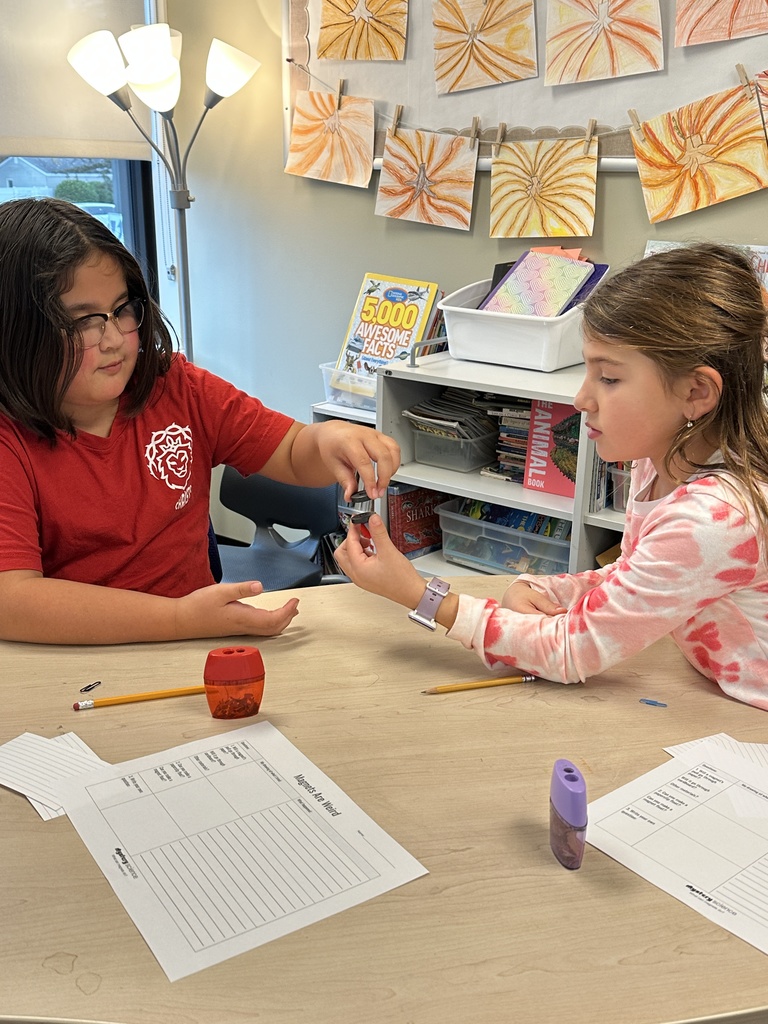 two students holding magnets and noticing how they repel each other