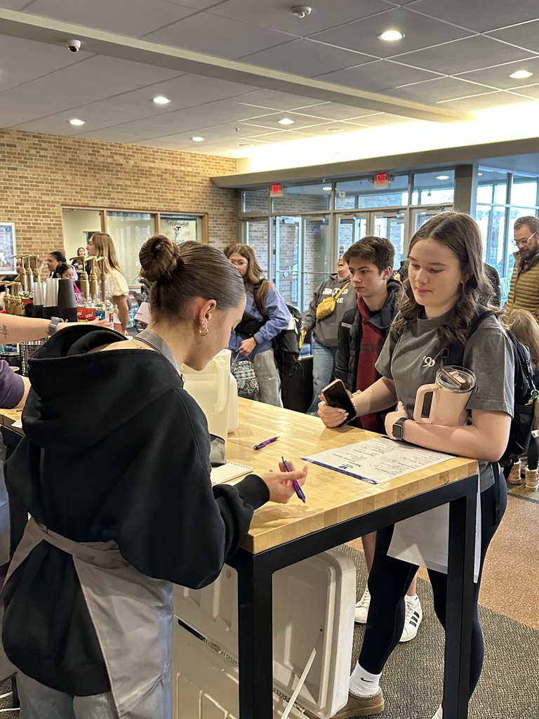 student taking a coffee order from a different student