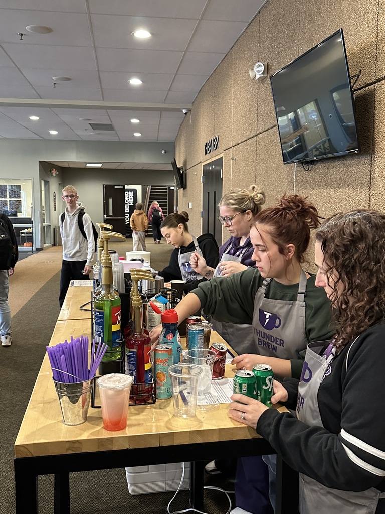 four people working as baristas at a coffee cart