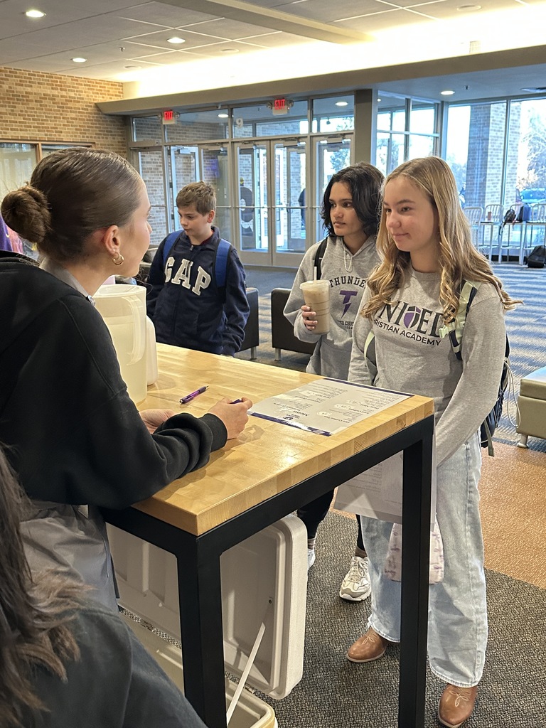 student taking a coffee order from a different student