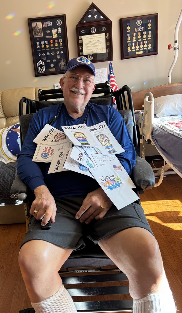 military veteran smiling with cards made by kindergarten students