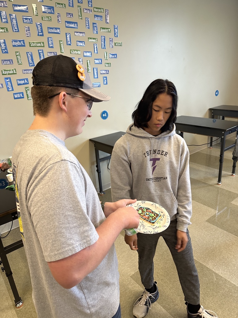 students using frosting to decorate a cookie to look like a cell 