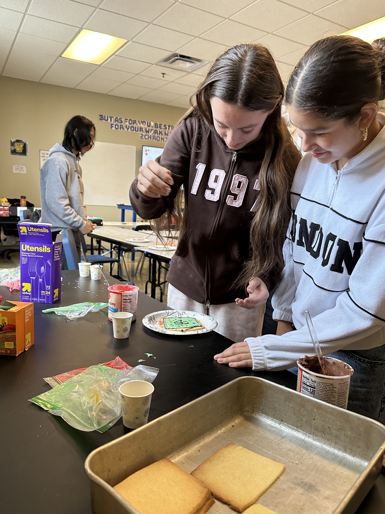 students using frosting to decorate a cookie to look like a cell 