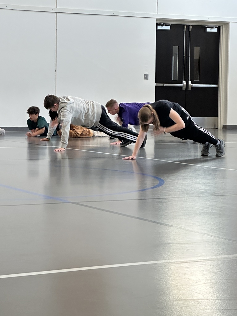 group of high school students learning exercises for specific muscle groups