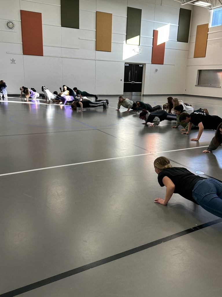 group of high school students learning exercises for specific muscle groups