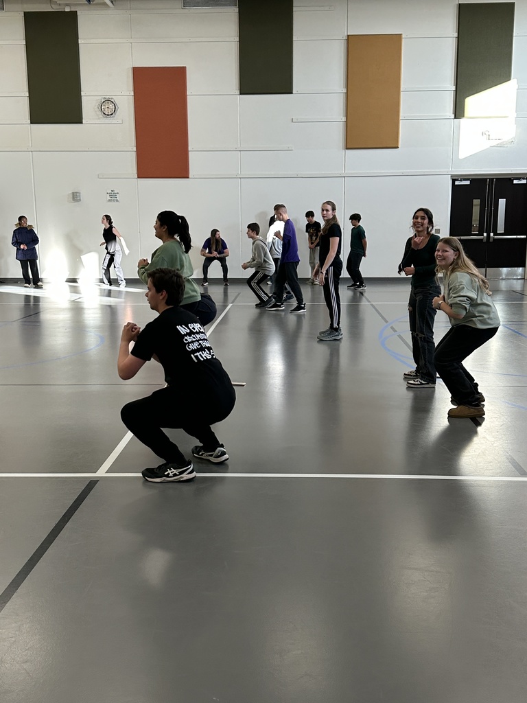 group of high school students learning exercises for specific muscle groups