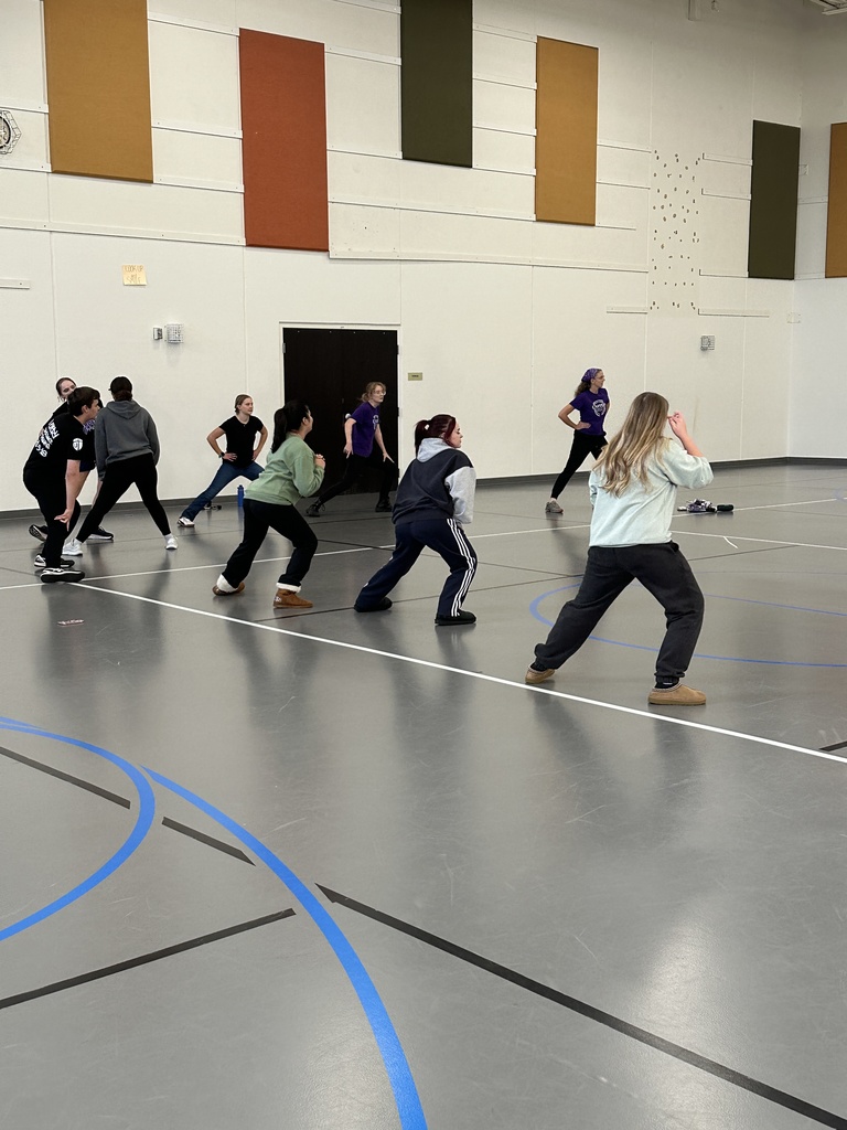 group of high school students learning exercises for specific muscle groups