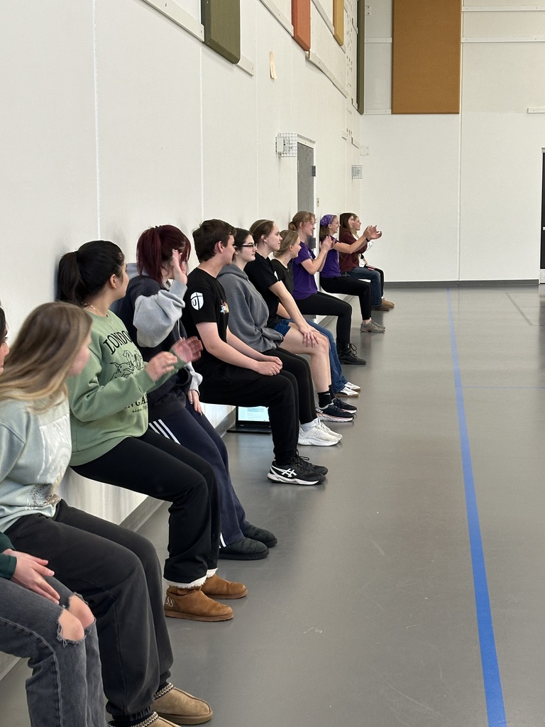 group of high school students learning exercises for specific muscle groups