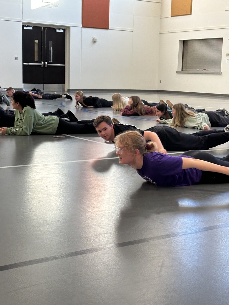 group of high school students learning exercises for specific muscle groups