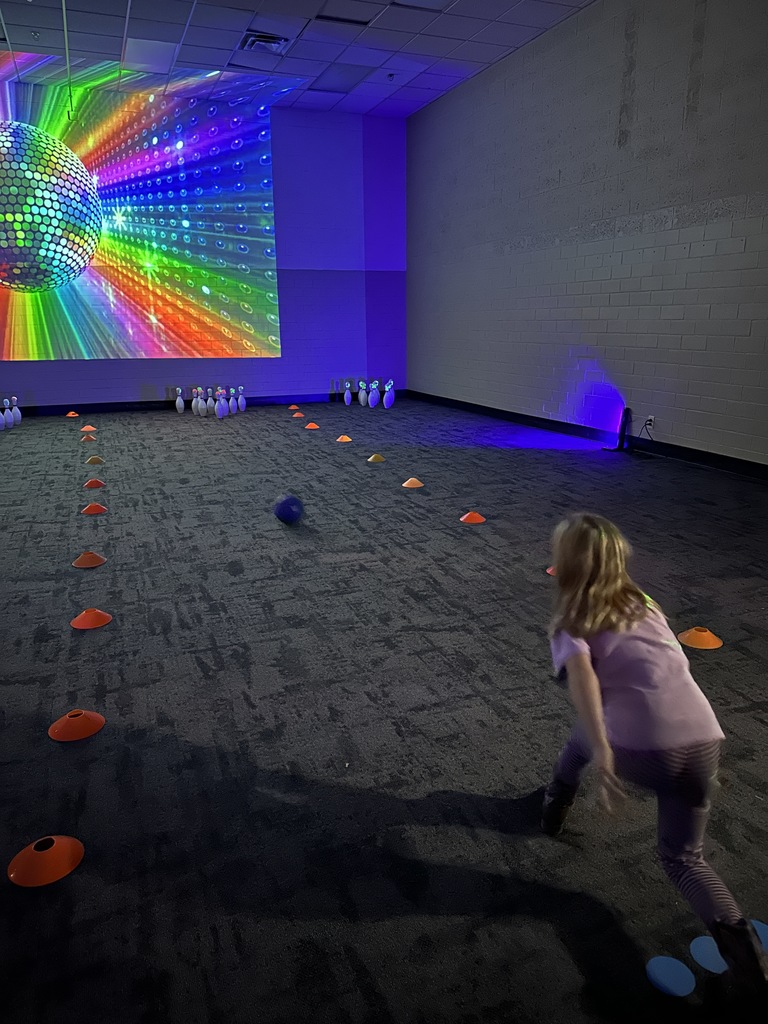 elementary student rolling a bowling ball
