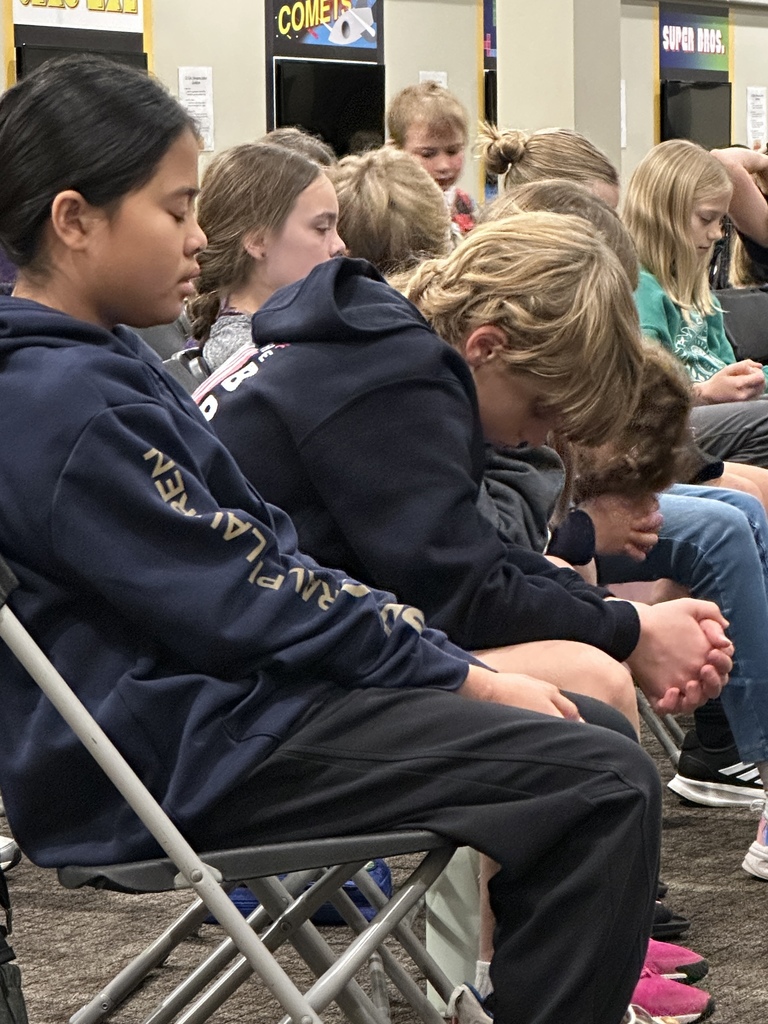 students praying during a chapel service