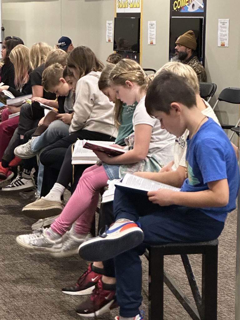 Row of students sitting and reading their bibles