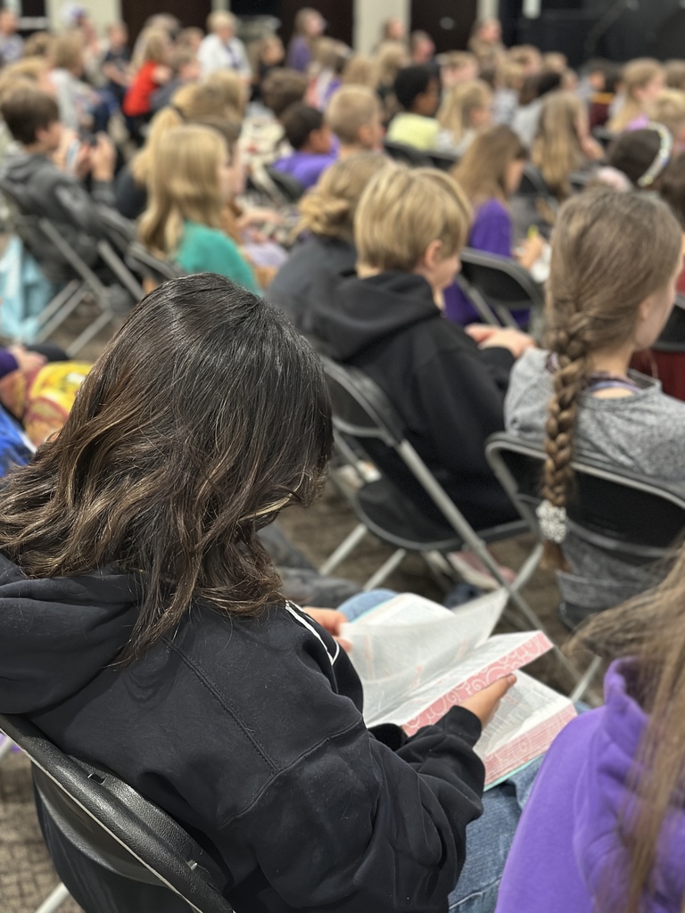 a student reading her bible during a chapel service