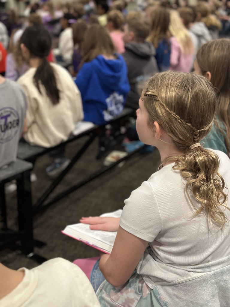 a student reading her bible during a chapel service