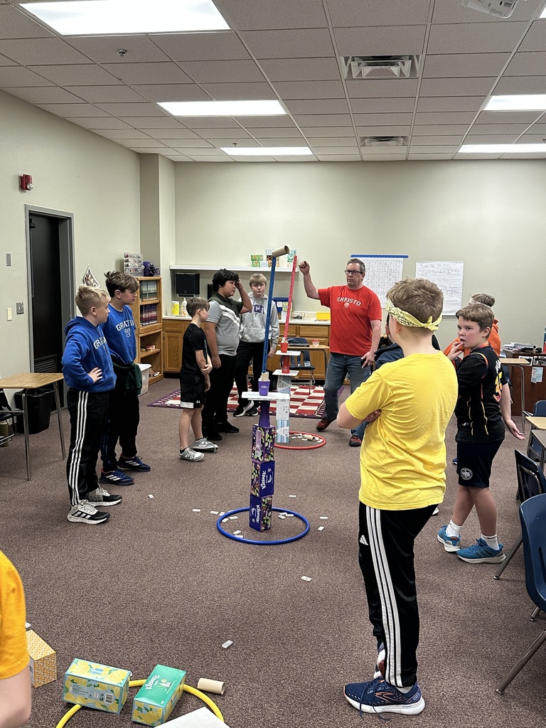 teacher checking the height of the towers that students built