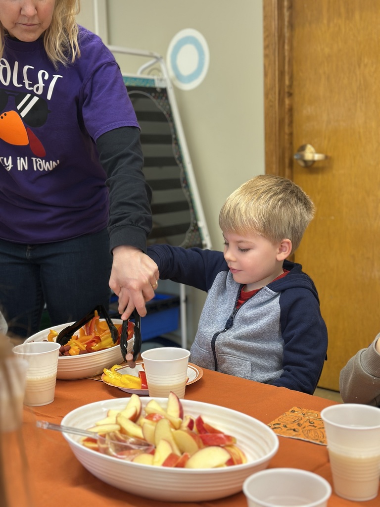 teacher helping student put food on his plate