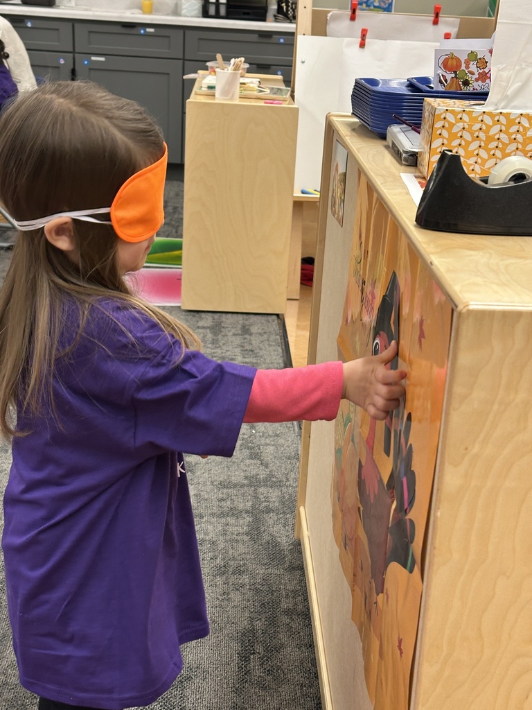 student playing "pin the feather on the turkey"